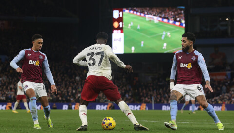 Kobbie Mainoo med ballen i beina foran to Aston Villa-spillere.