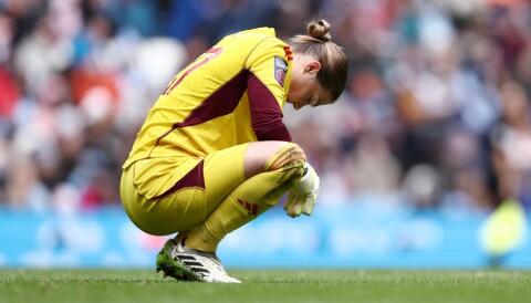 En skuffet Mary Earps sitter på huk under kampen mot Manchester City Women, 23. mars 2024.