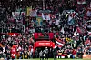 Manchester United-fans med røde og hvite flagg og bannere på tribunen på Old Trafford.