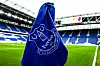 Blått Everton-cornerflagg står på en fotballbane i et tomt stadion med blå seter.