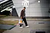 Diogo Dalot går over plassen ved Carrington med en bag og en drikkeflaske.