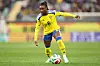 Svensk fotballspiller i gul drakt fører ballen på en gressbane.