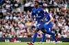 Kobbie Mainoo løper på banen i Manchester United-drakt foran tilskuere.