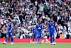 Manchester United-spillere i blå drakter står på banen foran en fullsatt tribune.