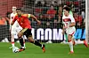 Belgisk spiller fører ballen foran en tyrkisk motspiller på fotballbanen.
