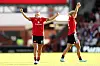 To Manchester United-spillere i røde drakter jubler med armene hevet på fotballbanen.