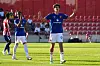 Manchester United-spiller i blå drakt løfter armene under en ungdomskamp mot Atlético de Madrid.