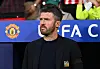 Michael Carrick i svart jakke foran Manchester Uniteds logo og en blå UEFA-profil.