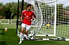 Noah Ajayi i Manchester United-drakt står foran målet og nettet på en fotballbane.
